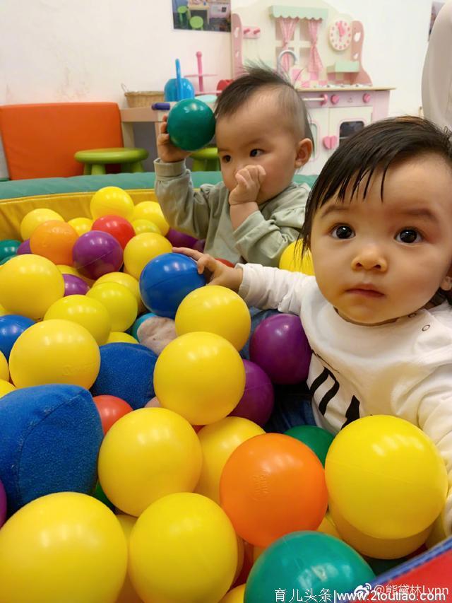 熊黛林带11个月大的双胞胎女儿上早教课，一个专心玩一个使劲吃